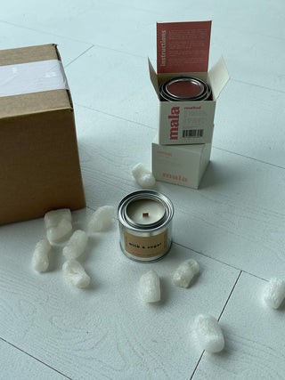mala core collection on a white wood floor with packing peanuts, a cardboard shipping box, and candle boxes