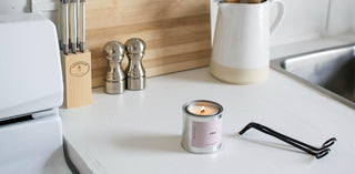 chai candle on a kitchen counter with a wick trimmer beside